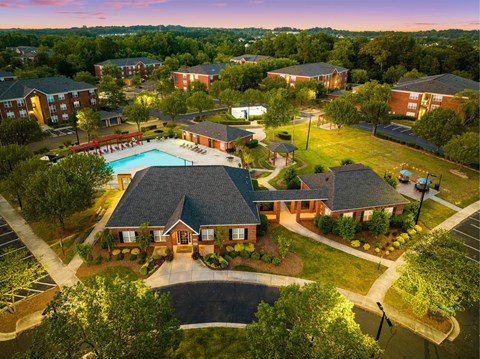 A large building with a pool in front of it.