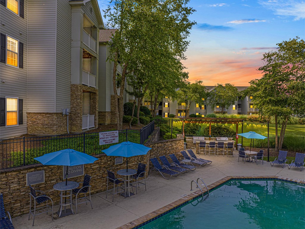a swimming pool with umbrellas at dusk
