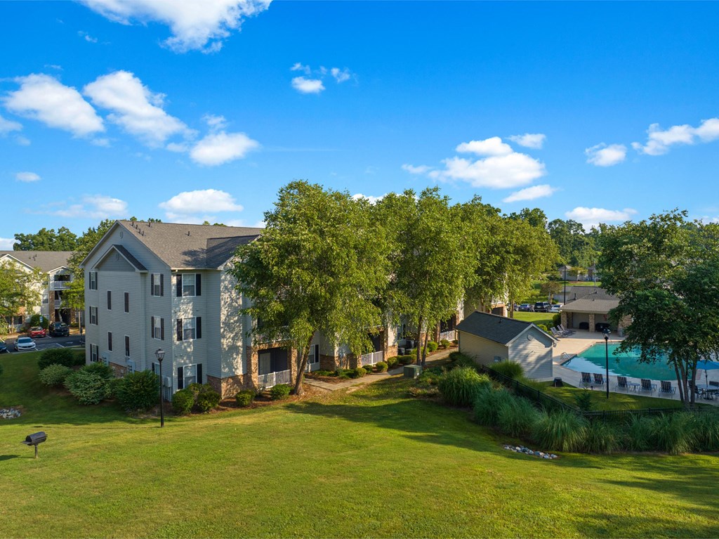 an aerial view of an apartment complex with green grass and trees