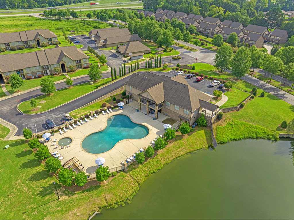 an aerial view of a swimming pool in front of a house