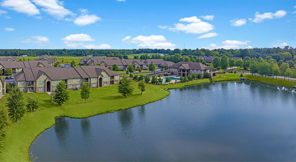 an aerial view of a pond with houses next to it