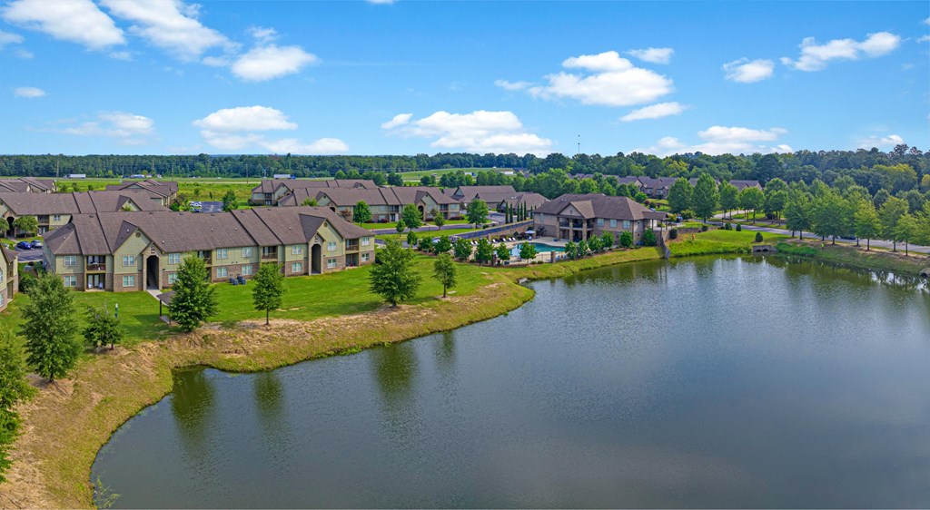 an aerial view of a pond with houses next to it