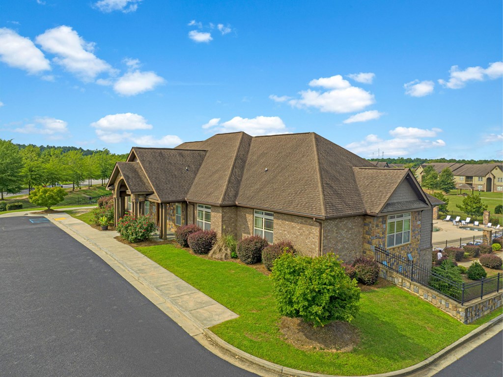 a large brick house with a brown roof and a green lawn