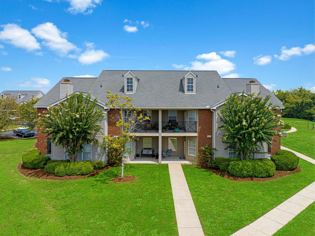 a house with a lawn and trees in front of it