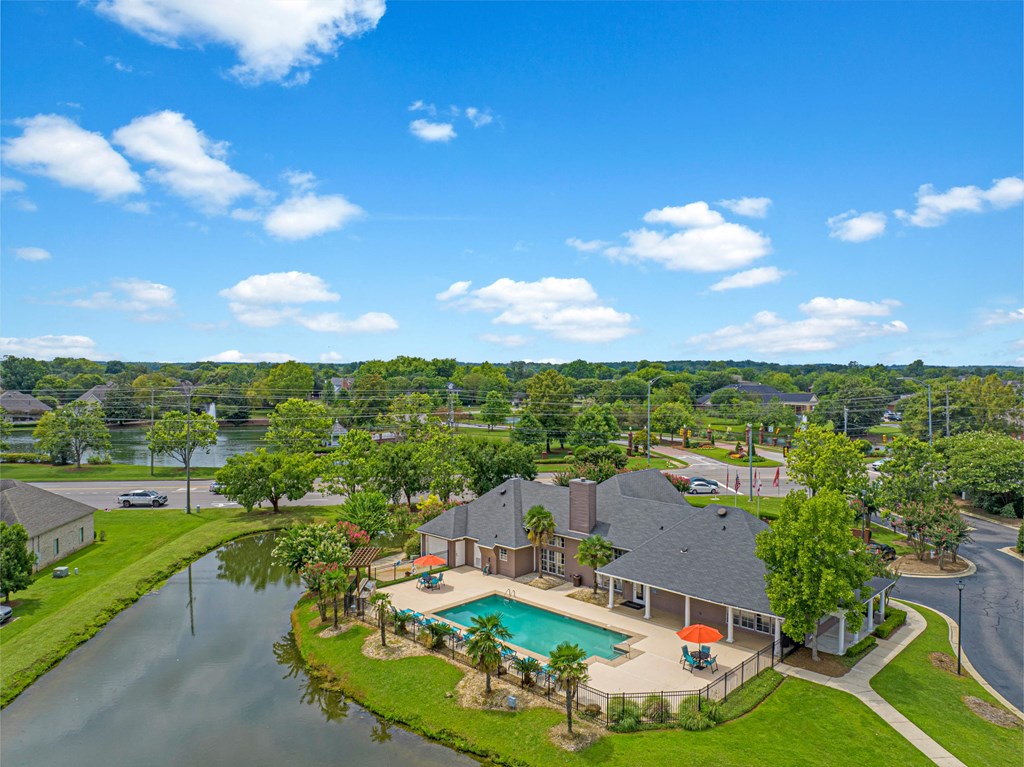 an aerial view of a house with a pool and a lake
