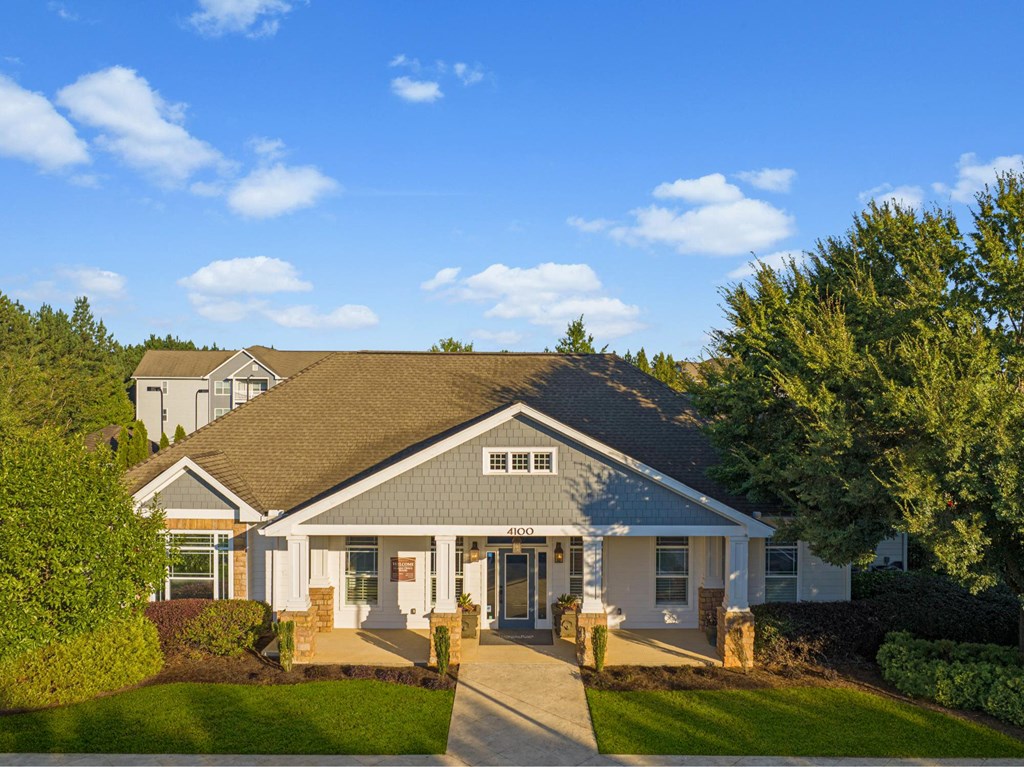 the front of a house with a driveway and trees