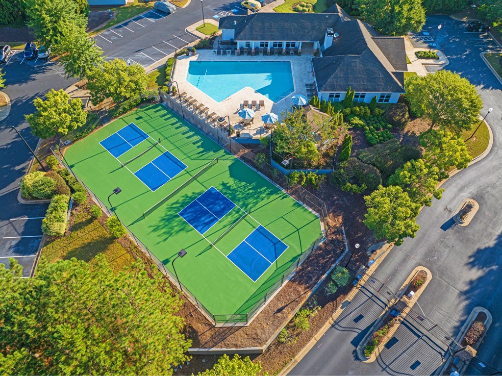 arial view of a tennis court and a clubhouse with a pool