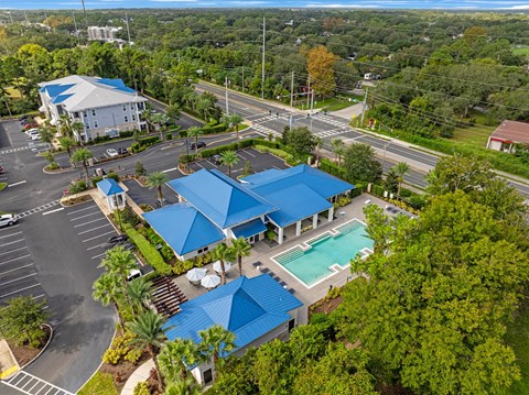 a property with blue roofs and a swimming pool in a parking lot