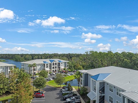 an aerial view of apartment buildings with a lake in the background