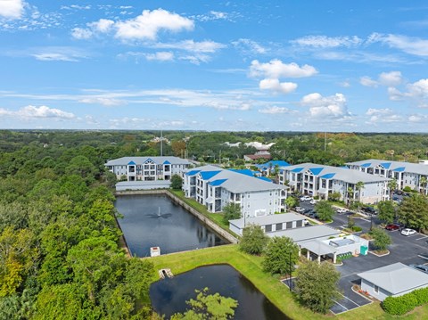 an aerial view of a resort with a lake and buildings