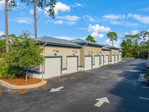 an empty parking lot with a row of garages