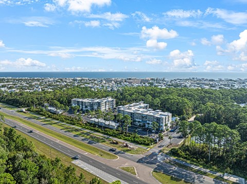 an aerial view of a city with trees and the ocean