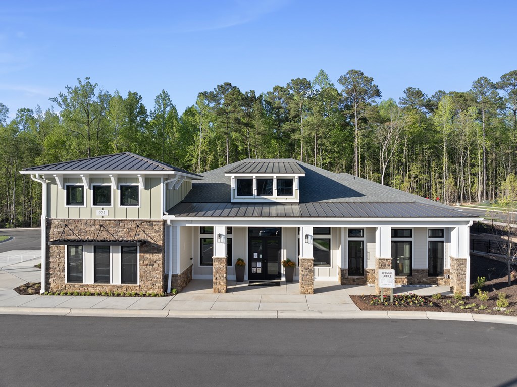 A house with a stone wall and a black roof.