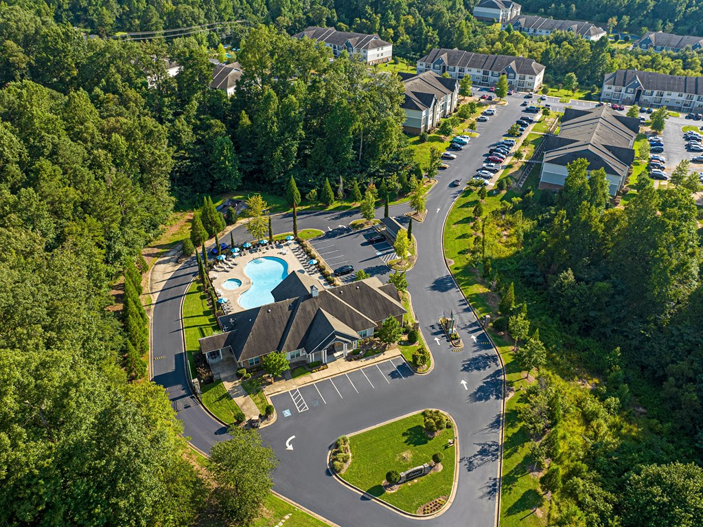 an aerial view of a resort with a swimming pool and parking lot