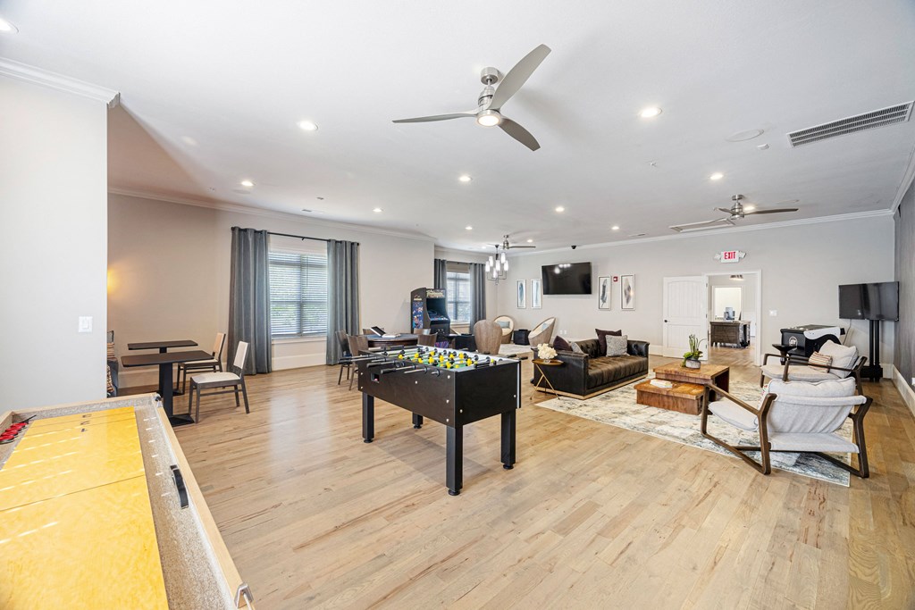 a living room with a pool table and a ceiling fan