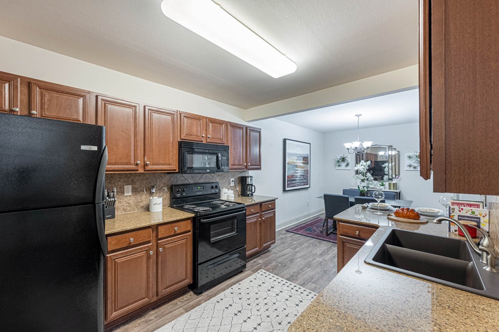 a kitchen with black appliances and wooden cabinets
