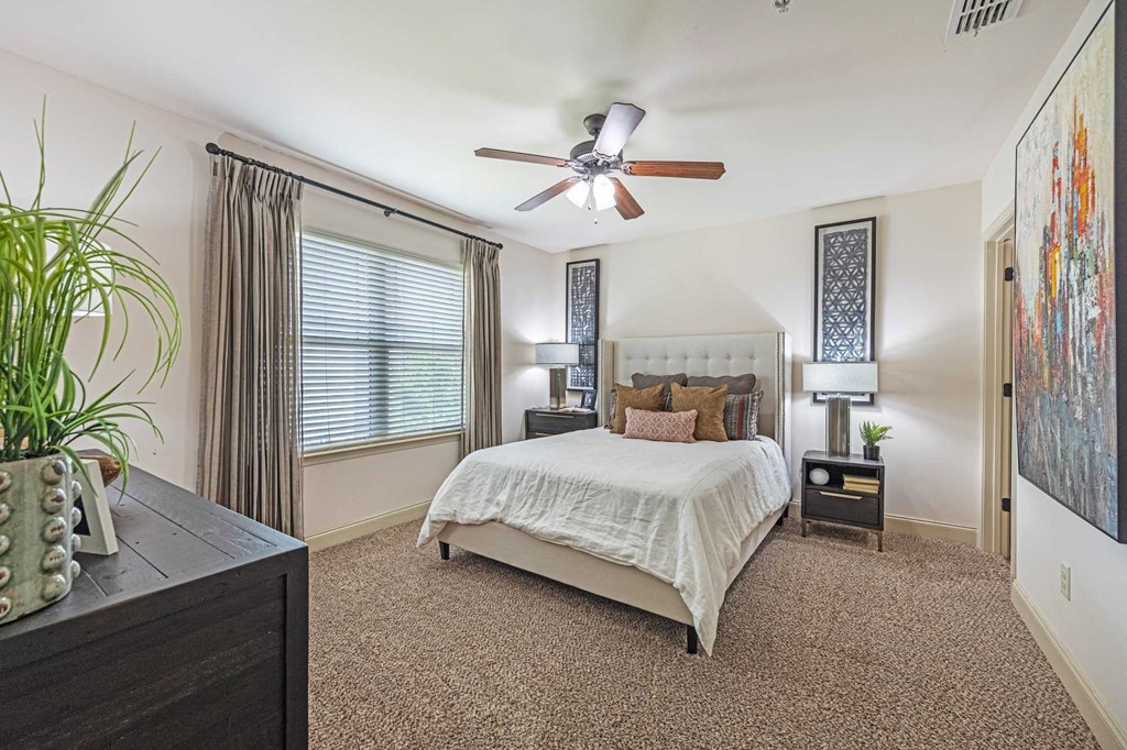 a bedroom with a bed and a ceiling fan