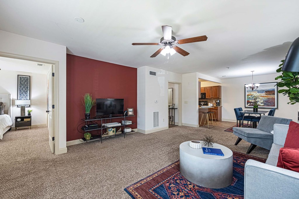 a living room with furniture and a ceiling fan