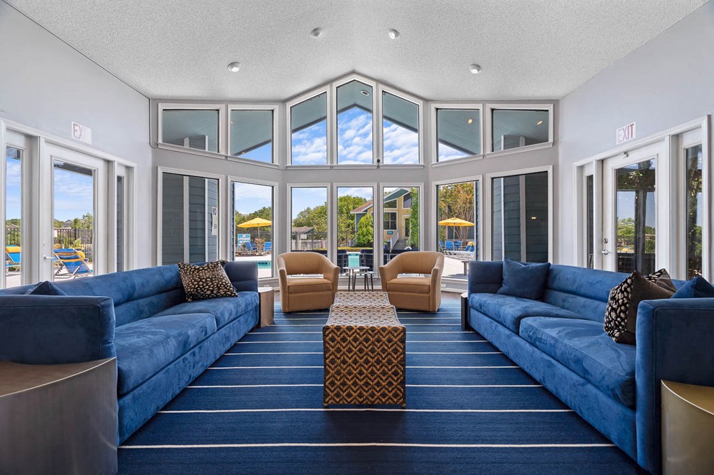 a living room with blue couches and chairs and a table