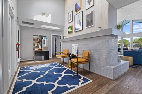 a living room with a fireplace and a blue rug