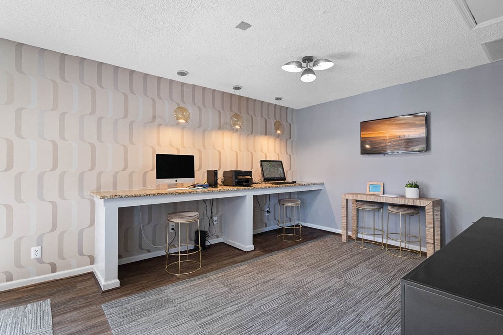 a home office with a desk and two stools