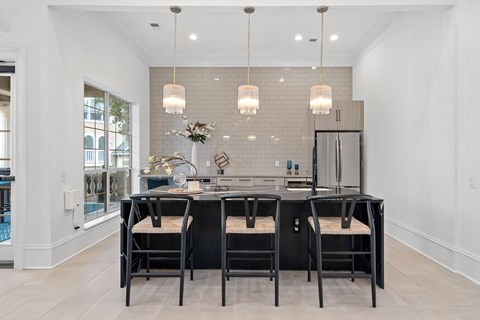 a kitchen with a black island and black chairs