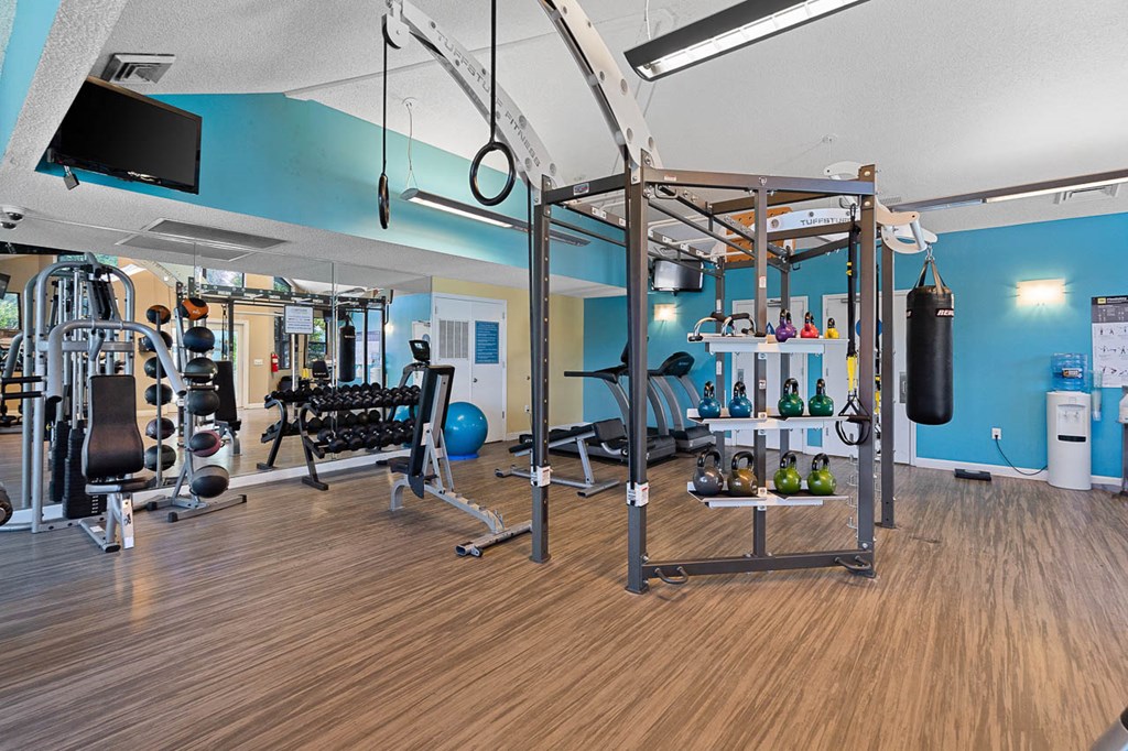 a gym with weights and other gym equipment on a wood floor