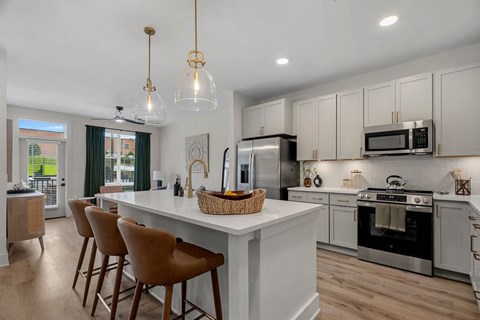 A modern kitchen with white cabinets and a large island.
