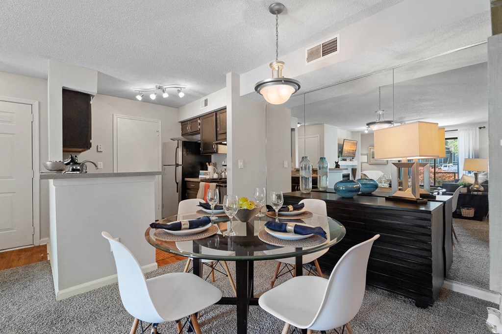 a dining room table with chairs next to a kitchen