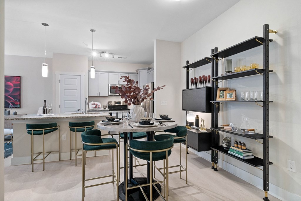 a dining room with a table and chairs and a kitchen with a tv