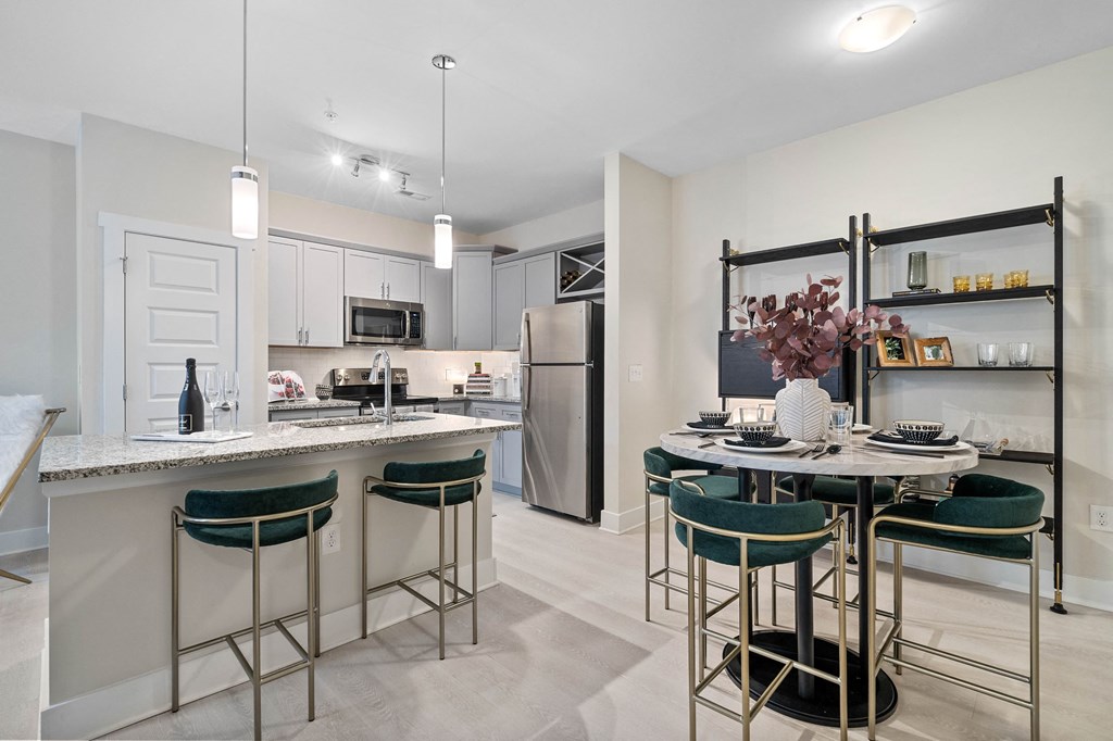 an open kitchen and dining area with a center island and bar stools