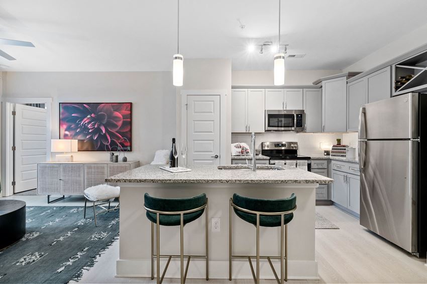 a kitchen with a marble counter top and three stools