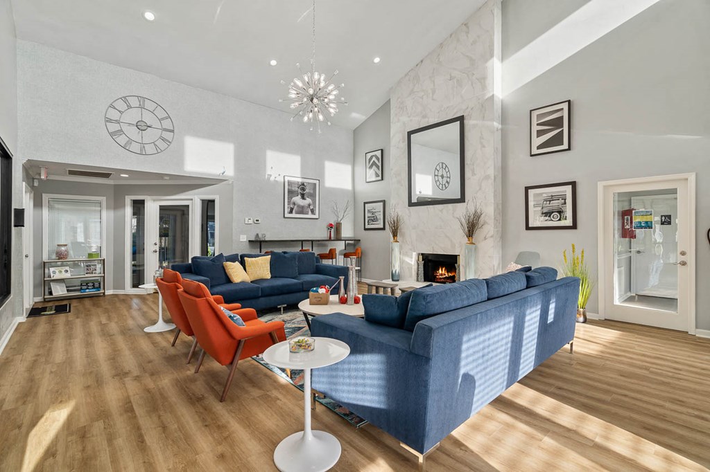 a living room with blue couches and chairs and a fireplace