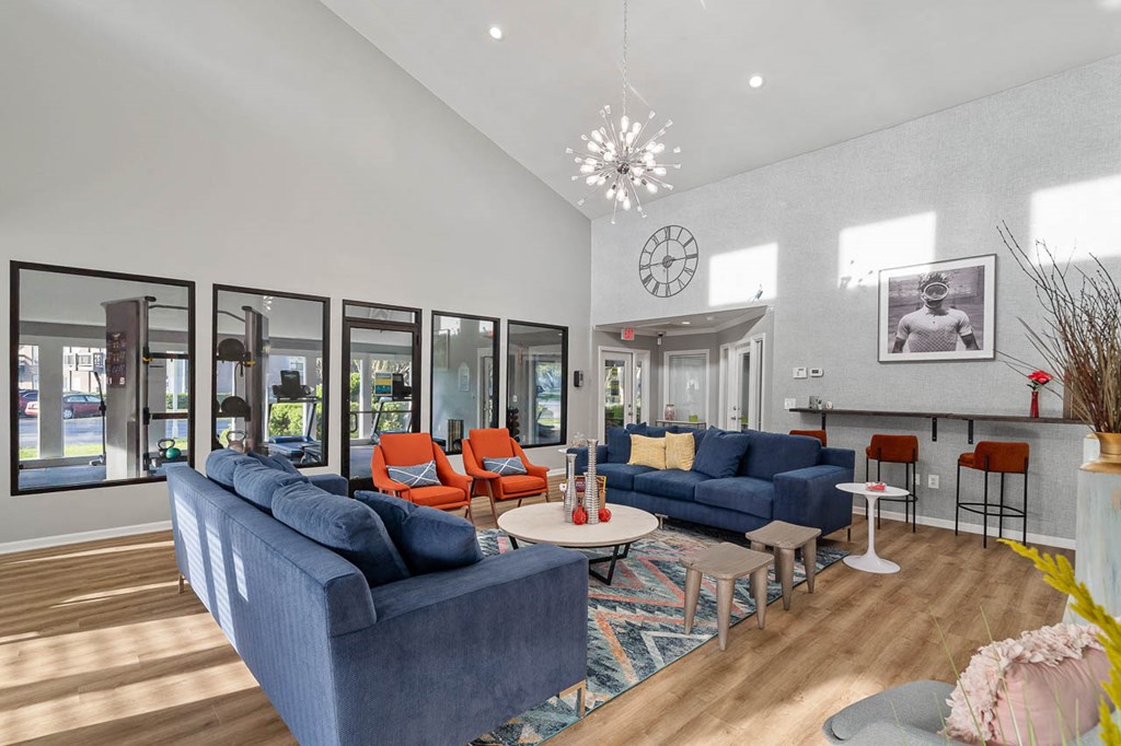 a living room with blue couches and a clock on the wall