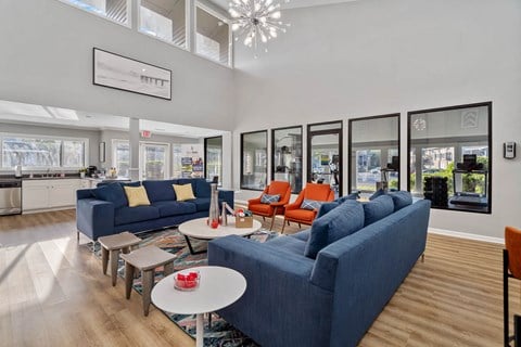 a living room with blue couches and a table with chairs