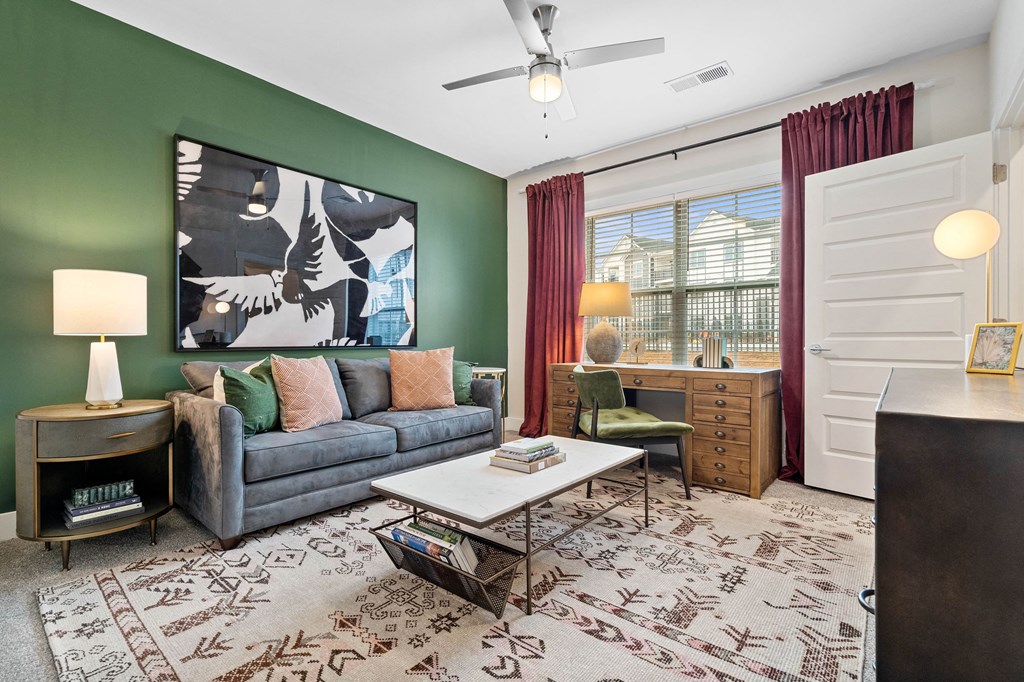 a living room with green walls and a gray couch