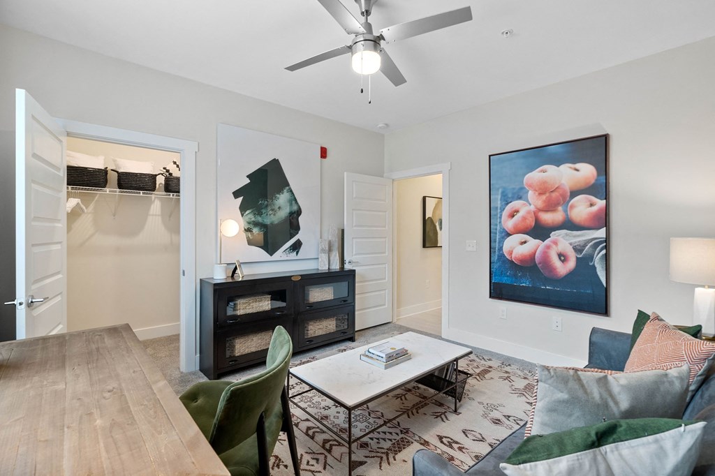 a living room with white walls and a ceiling fan
