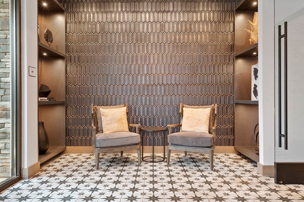 a pair of chairs in front of a wall with a tiled floor