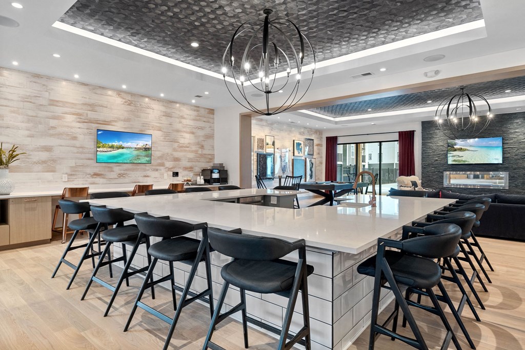 a large kitchen with a bar and chairs in a lobby