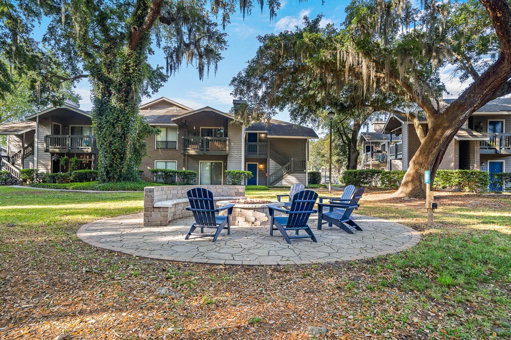 an outdoor patio with chairs and a fire pit