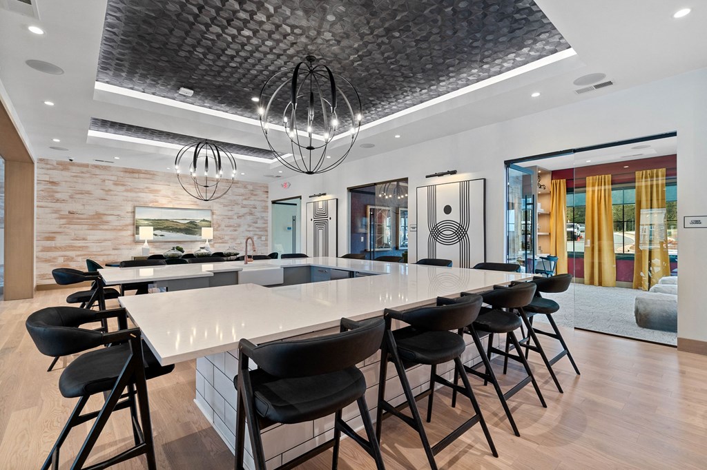 a long table with chairs in a room with a kitchen