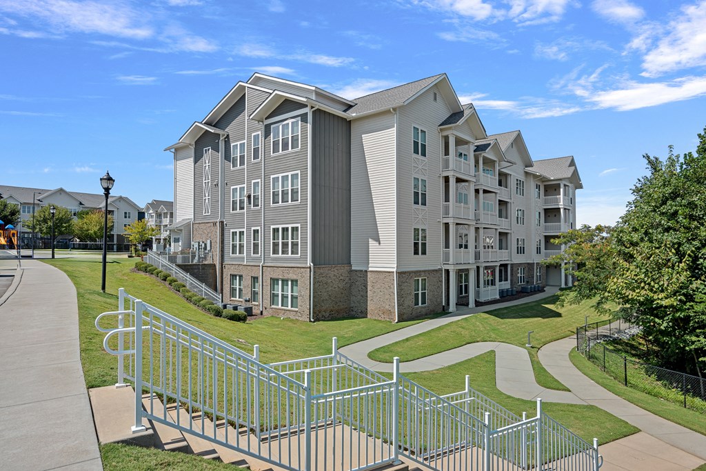 an apartment building with stairs and a sidewalk