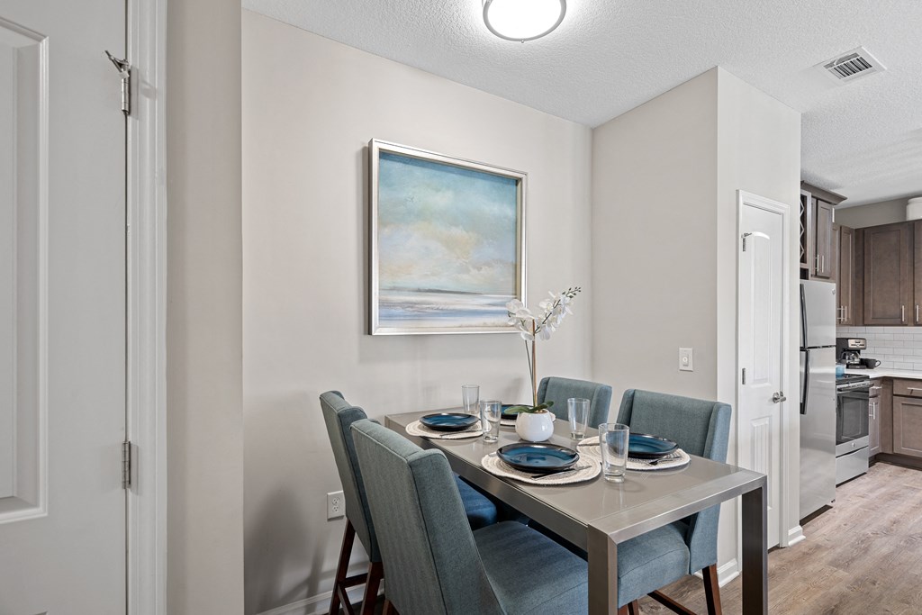 a dining room with a table and chairs and a painting on the wall