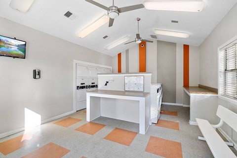 A kitchen with orange tiles on the floor and white cabinets.