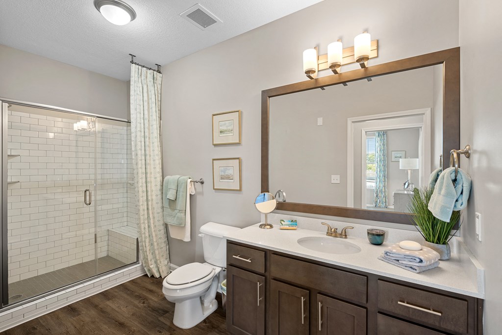 a bathroom with a large mirror and a shower and a sink