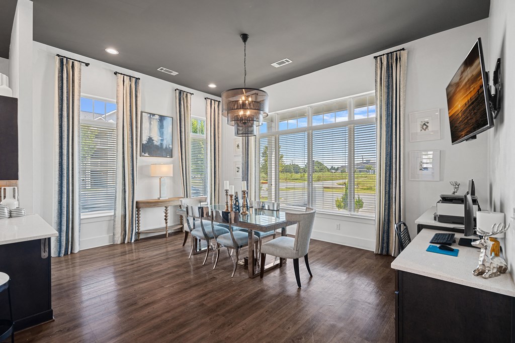 a dining room with a table and chairs and large windows