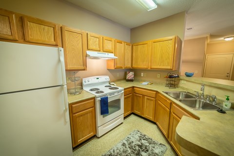 A kitchen with wooden cabinets and a white refrigerator.