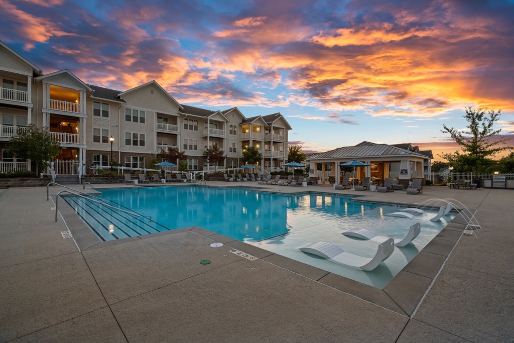 a pool with a reflection of a building and a cloudy sky