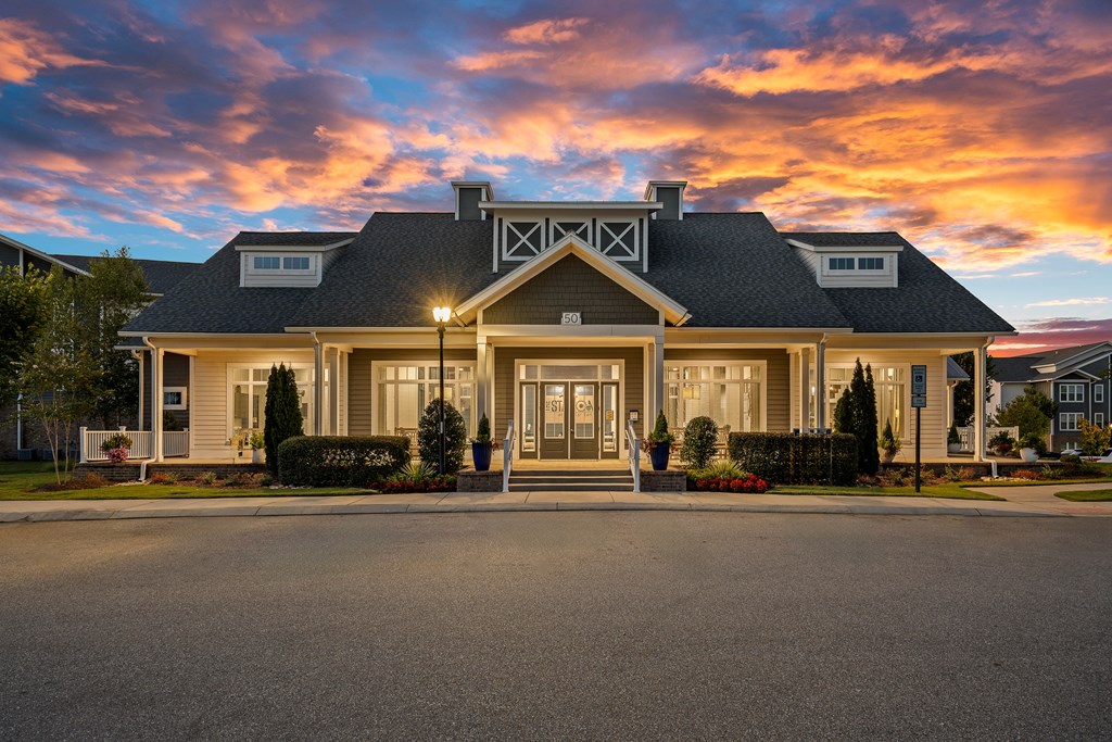 the front of a house with a sunset in the background