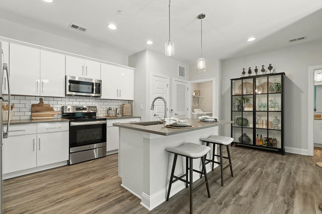 White Custom Cabinetry with Pendant Lights and Stainless Steel Appliances